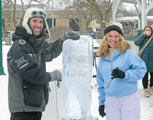 Bob Lechtenberg, of Hartford, finishes an ice carving demonstration with Layla Kaplan from Orlando, Florida.